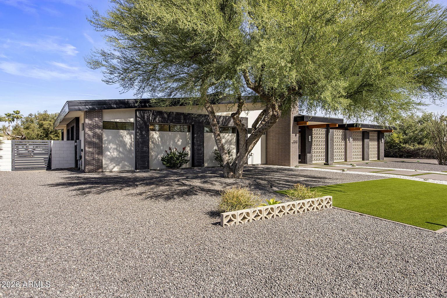 Side angle of the entry showing the ocotillo planter, breeze-block screens, and brick volumes that define the curb side.